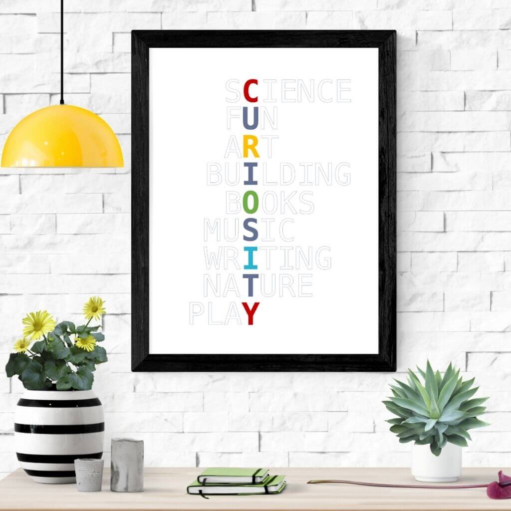 Playroom wall art with Curiosity written in primary colors vertically, with grayed out words intersecting horizontally. From top, they read Science, Fun, Art, Building, Books, Music, Writing, Nature, Play.