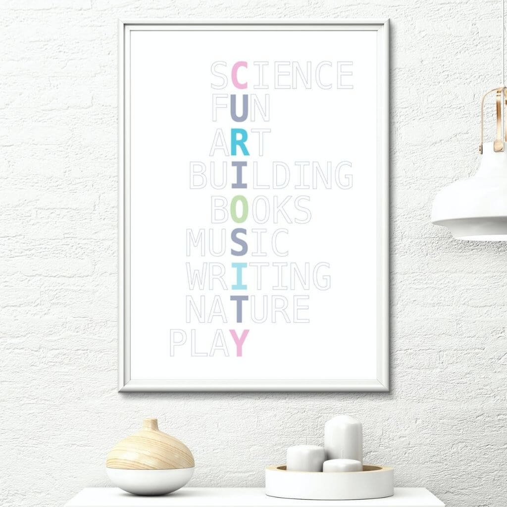 Playroom wall art with Curiosity written in pastel colors vertically, with grayed out words intersecting horizontally. From top, they read Science, Fun, Art, Building, Books, Music, Writing, Nature, Play.