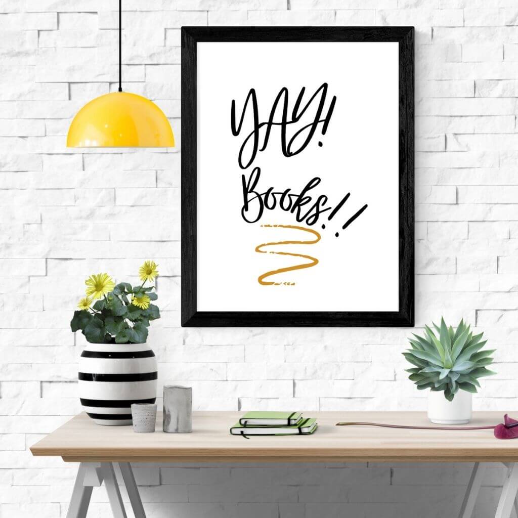 Printable reading poster on a white brick wall in a black frame that reads YAY! Books!! with a gold underline